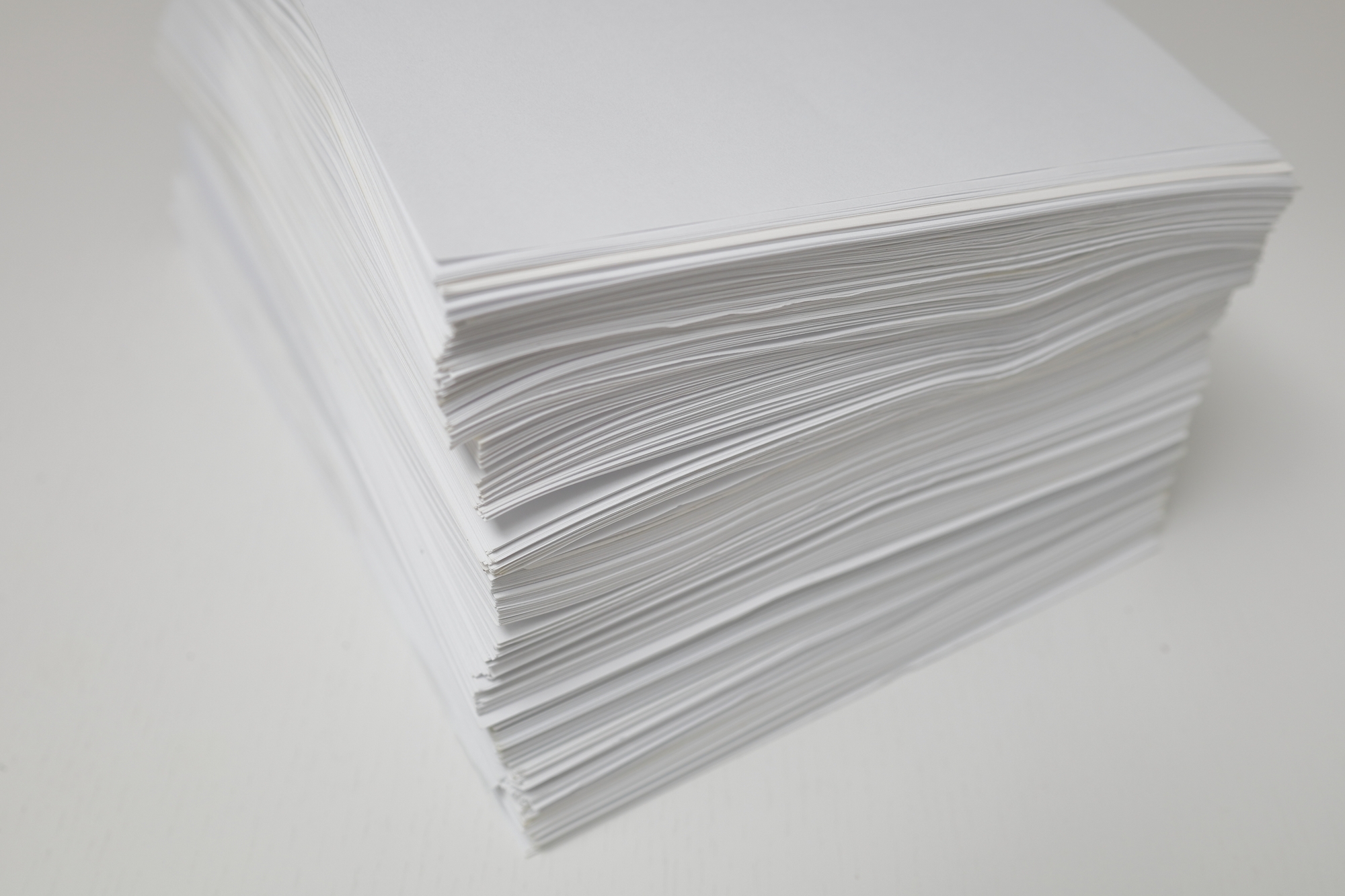 山積みの書類 - 紙資料の課題